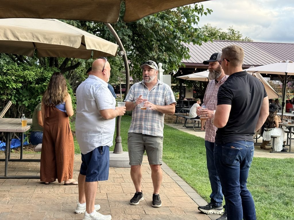 Sphinx teammates catching up over drinks on a patio